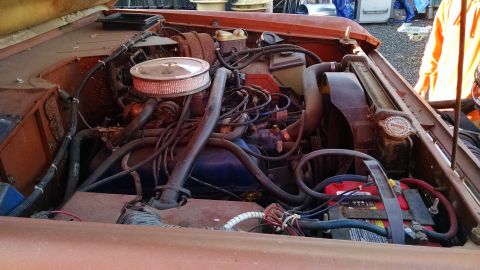 1985 Jeep CJ7 - The engine bay of a vehicle, showing the V8 engine components and battery.