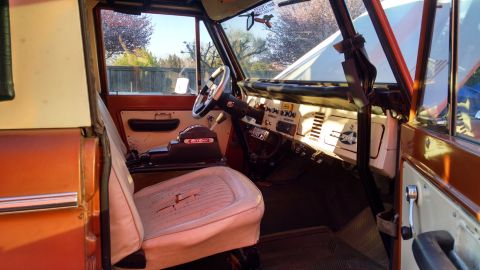1985 Jeep CJ7 - The interior of a classic Ford Bronco is visible, worn seats and a dashboard with various controls.