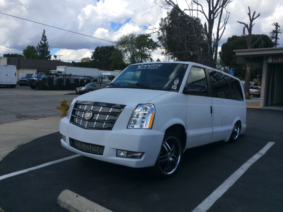 White van with Cadillac Escalade front end conversion, parked in a lot
