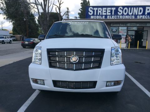 1968 Ford Mustang - Front view of a white Cadillac Escalade parked in front of a storefront.