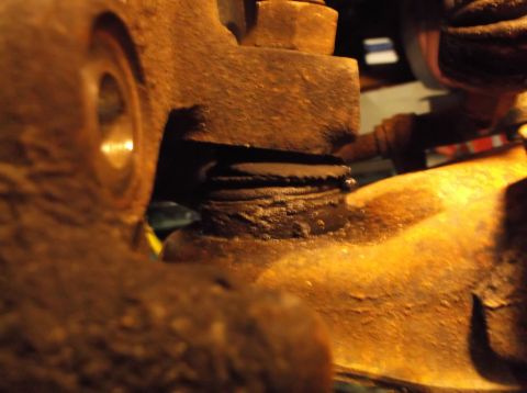 1999 Mercury Grand Marquis - This close-up shows a rusty ball joint assembly with a serrated edge, likely part of a vehicle's suspension system.