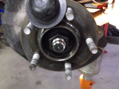 1999 Mercury Grand Marquis - This is a close-up view of a vehicle's wheel hub assembly, showing the lug studs and the central nut.