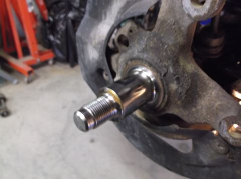 1999 Mercury Grand Marquis - A close-up view of a vehicle's wheel hub assembly, showing a shiny metal stud.