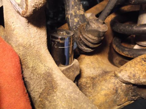 1999 Mercury Grand Marquis - A 24mm socket wrench is shown on a vehicle's suspension component.