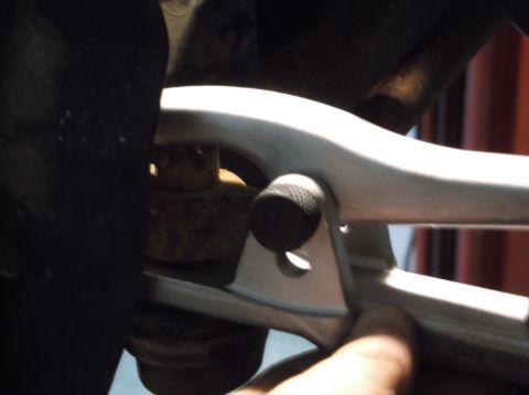 1999 Mercury Grand Marquis - A wrench is used on a suspension component, obscuring the vehicle's identity.