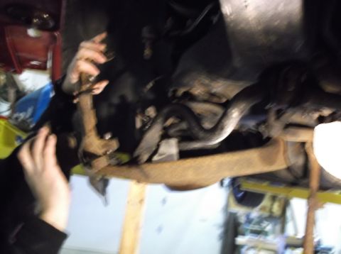 1999 Mercury Grand Marquis - Mechanic's hands work on a suspension component, likely during a front-end rebuild.