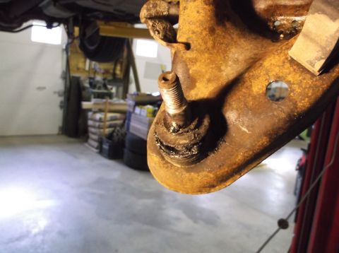 1999 Mercury Grand Marquis - Close-up of a heavily rusted ball joint, indicating wear and the need for a front end rebuild.