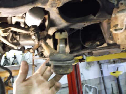 1999 Mercury Grand Marquis - Mechanic's hand holding a ball joint during a suspension inspection.