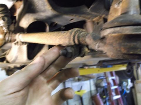 1999 Mercury Grand Marquis - Close-up of a rusty tie rod end, part of a vehicle's suspension system.