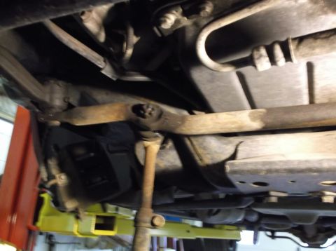 1999 Mercury Grand Marquis - Close-up of the underside of a car, showing suspension parts and fuel lines.