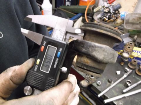 1999 Mercury Grand Marquis - A digital caliper measures a suspension component to 10.59 inches, likely for a front-end rebuild.