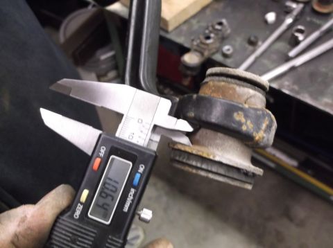 1999 Mercury Grand Marquis - Measuring a suspension part with digital calipers, showing a reading of 106.4.