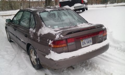 1996 Subaru Legacy - A 1996 Subaru Legacy sedan is seen parked in the snow.