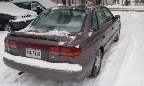 1996 Subaru Legacy - 1996 Subaru Legacy sedan covered in snow, parked next to another vehicle.