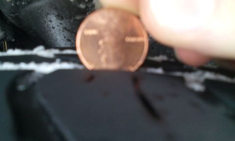 1996 Subaru Legacy - Tire tread depth is being measured using a penny.
