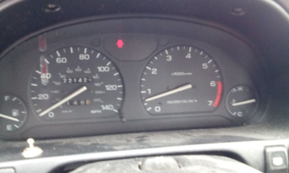 Car dashboard with speedometer showing 221425 miles and tachometer