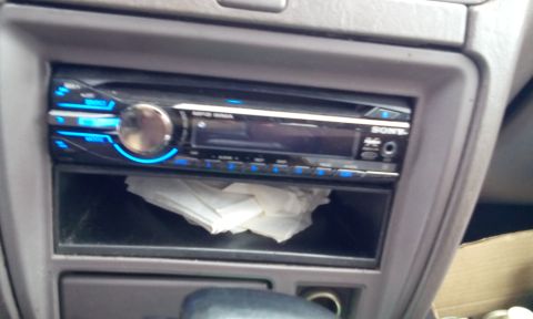 1996 Subaru Legacy - Close-up of a Sony car stereo with blue lighting and a storage compartment below.