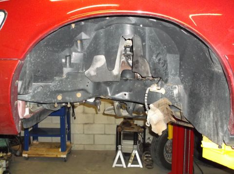 1999 Mercury Grand Marquis - Vehicle's front wheel well and suspension components are visible during a repair process.
