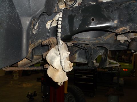 1999 Mercury Grand Marquis - Underside view of a vehicle's brake system, showing the caliper and brake line.