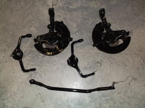 1999 Mercury Grand Marquis - Painted steering knuckles and sway bar laid out on a concrete floor.