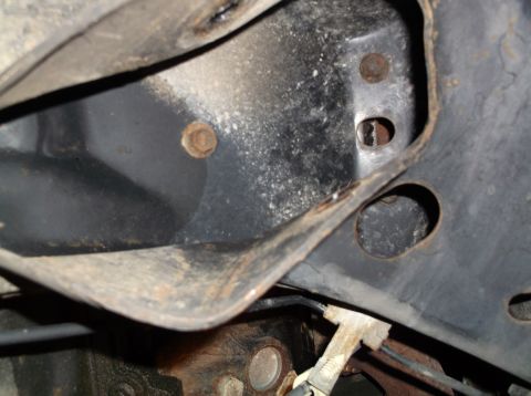 1999 Mercury Grand Marquis - Undercarriage view of rusted vehicle frame and suspension components.