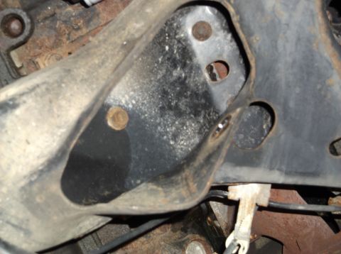 1999 Mercury Grand Marquis - A close-up view of a vehicle's undercarriage shows a metal bracket with signs of rust and wear.