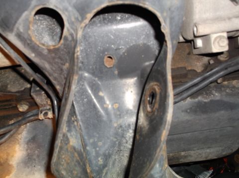 1999 Mercury Grand Marquis - Close-up view of a rusted vehicle frame component with hoses attached.