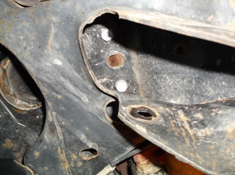 1999 Mercury Grand Marquis - Underside view of vehicle frame components showing rust and bolted connections.