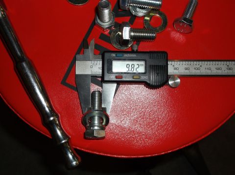 1999 Mercury Grand Marquis - A digital caliper measures bolts and washers on a red surface, with a ratchet handle visible.