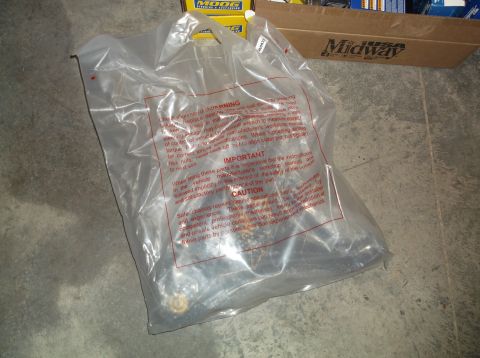 1999 Mercury Grand Marquis - A plastic bag holds automotive parts, with "MOOG" and "Midway" boxes visible in the background.