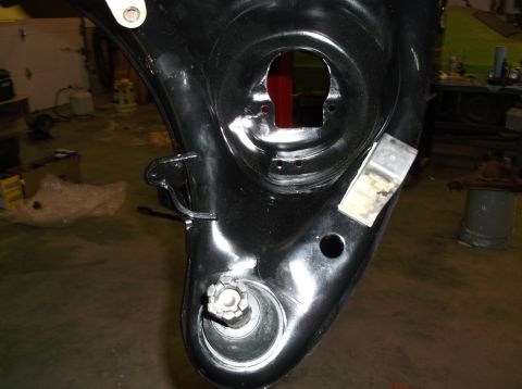 1999 Mercury Grand Marquis - Black-painted inner fender/quarter sheet-metal section with openings, on a workbench in a shop.