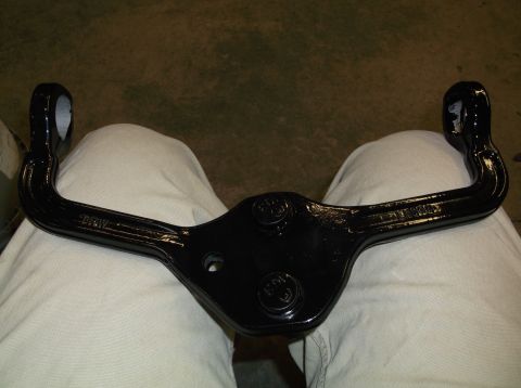 1999 Mercury Grand Marquis - A black suspension control arm with visible markings is held over someone's lap.