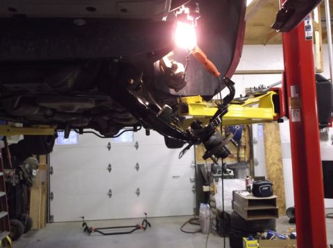 1999 Mercury Grand Marquis - Vehicle suspension components are visible while the car is raised on a lift for service.