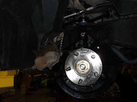 1999 Mercury Grand Marquis - The front end of a vehicle is shown with the wheel removed, revealing the brake and suspension system.