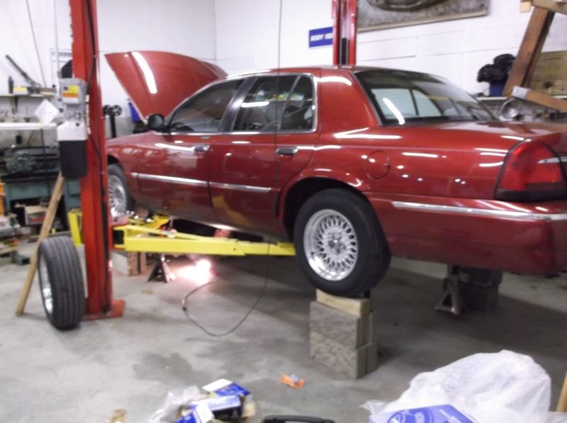Red 1999 Mercury Grand Marquis side view on lift