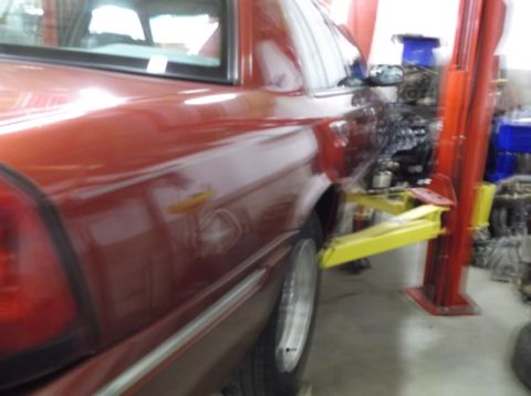 1999 Mercury Grand Marquis - Rear view of a 1999 Mercury Grand Marquis being worked on in a garage.