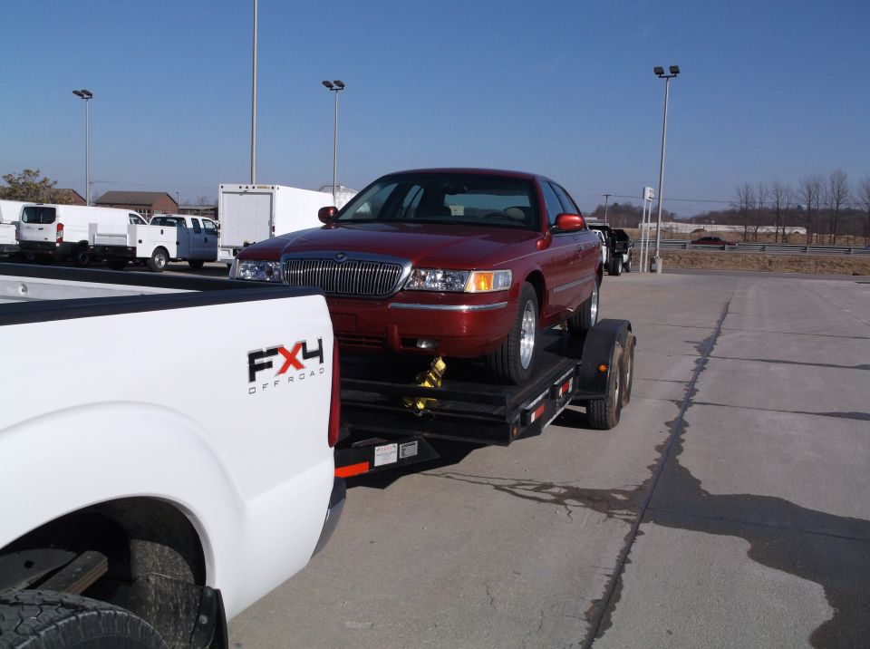 1999 Mercury Grand Marquis on a flatbed trailer, viewed from the front