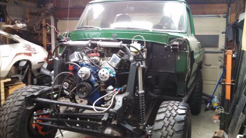 1967 Ford F-250 - Green 1967 Ford F-250 undergoing a build, showing its exposed engine and suspension modifications.
