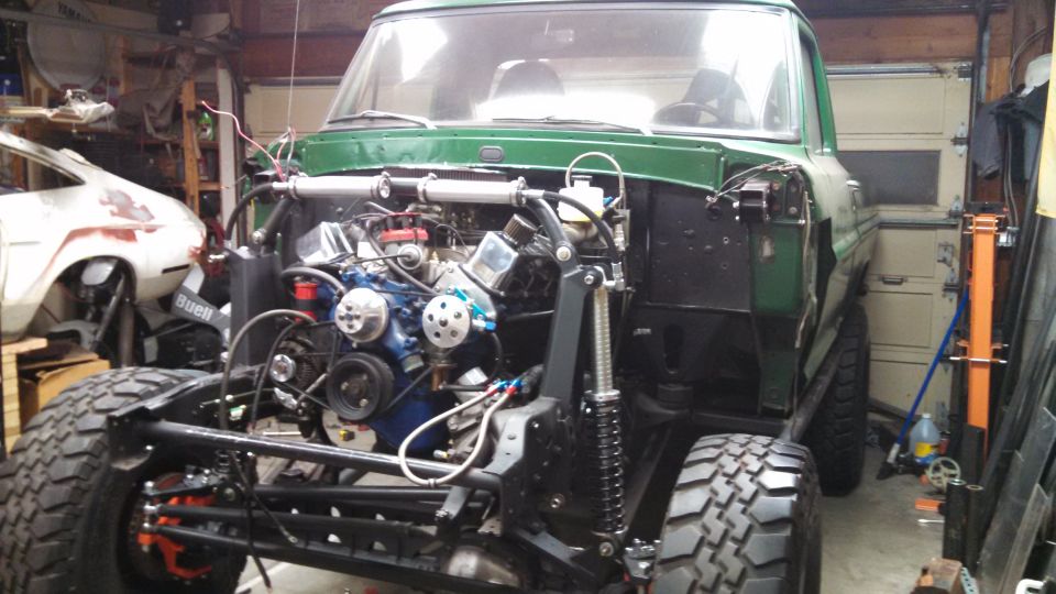 Green 1967 Ford F-250 front view with engine exposed during build