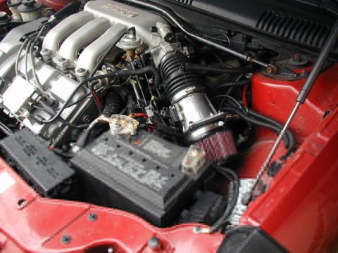 1998 Ford Taurus - Close-up of a car's engine bay, focusing on the battery and intake system.