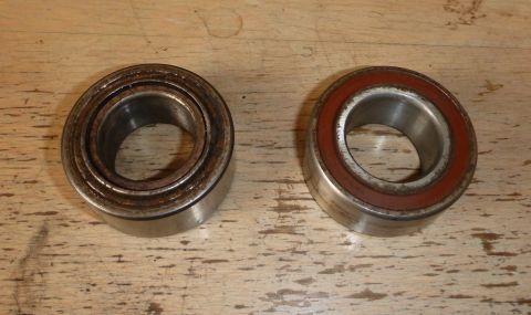 1964 Mercury Monterey - Two wheel bearings, one disassembled and one with a red seal, are shown on a wooden surface.