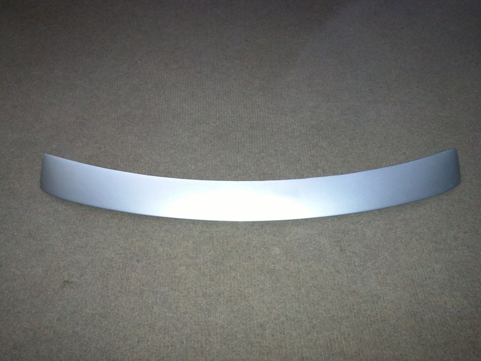 Curved silver trim piece on a textured gray background