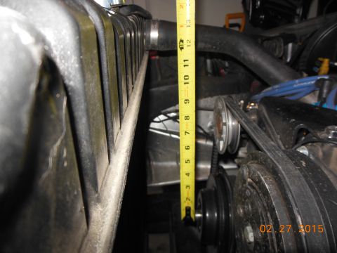1979 Ford F-150 - Close-up view of engine bay components, including a radiator and pulleys, with a measuring tape indicating dimensions.