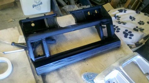 1982 Ford Bronco - A black dashboard trim piece, likely for a car interior, is shown on a workbench.