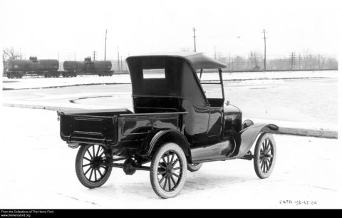 1909 Ford Model T - Rear view of a 1923 Ford Model T truck with a soft top and bed, with tank cars in the background.