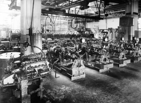 1909 Ford Model T - Engines are assembled on a factory floor, with multiple workstations visible in the background.
