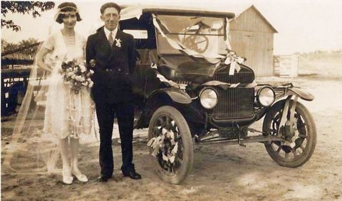 1909 Ford Model T - A newly married couple stands beside a decorated automobile, likely for a wedding procession.