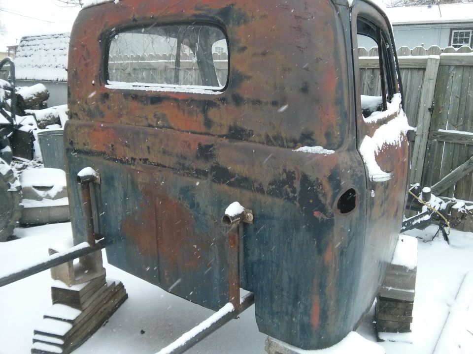 Rusted truck cab rear view in snow
