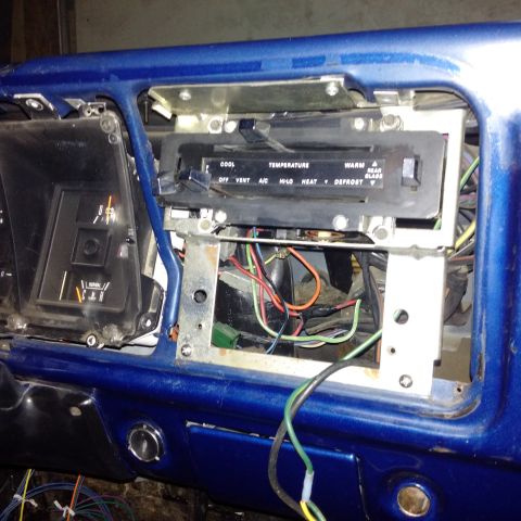 1978 Ford Bronco - The interior of a 1978 Ford Bronco shows the dashboard with climate controls and exposed wiring.