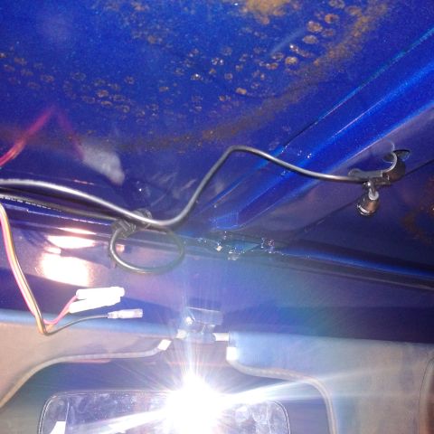 1978 Ford Bronco - Close-up of interior wiring and a rearview mirror, with blue painted metal above.
